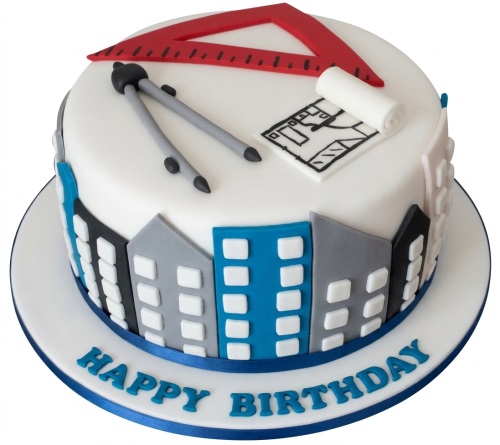 Round white architect birthday cake with red set square, compass, blueprint, and city skyline.