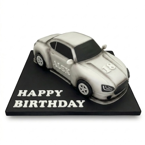 Grey and black racing car birthday cake with custom age and name on a black board.