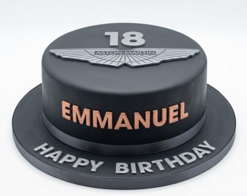 Dark grey Aston Martin birthday cake with silver logo and custom age topper.