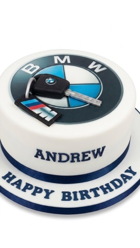 White round cake with BMW logo, edible car key, and personalised message.