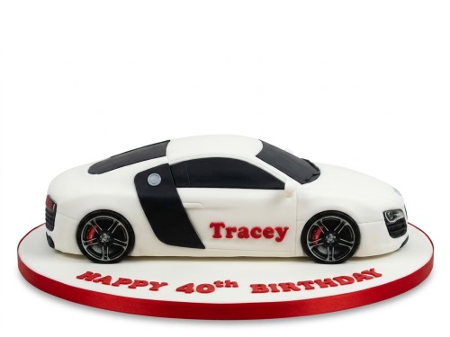 White luxury sports car cake with black accents and red lettering on a white and red cake board.