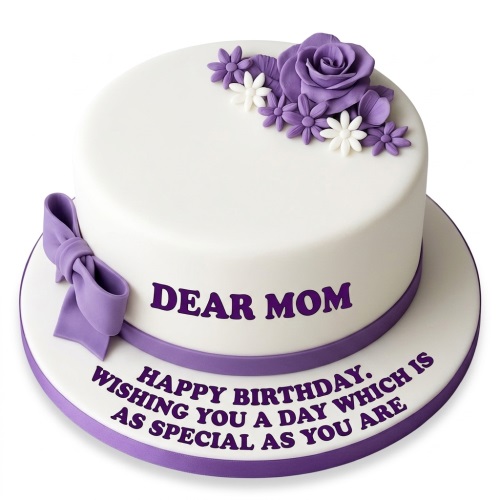 White round cake with purple sugar flowers, a purple bow, and a personalised message.