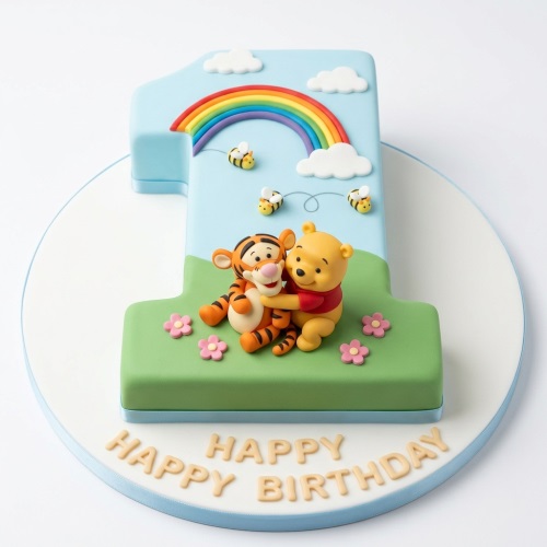 Number one shaped cake with Winnie the Pooh, Tigger, rainbow, clouds, bees, and flowers for a 1st birthday.