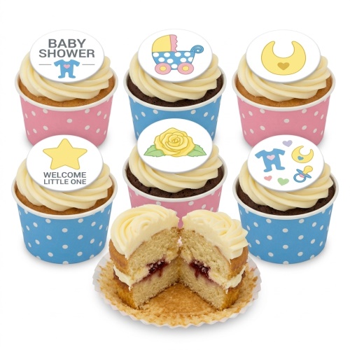 Cupcakes with white frosting, pink and blue polka dot wrappers, and baby shower themed toppers including a pram, bib, baby grow, and welcome little one star.