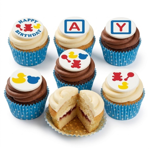 Selection of baby-themed birthday cupcakes with teddy bear, duck, rattle, and alphabet block toppers on vanilla and chocolate frosting.