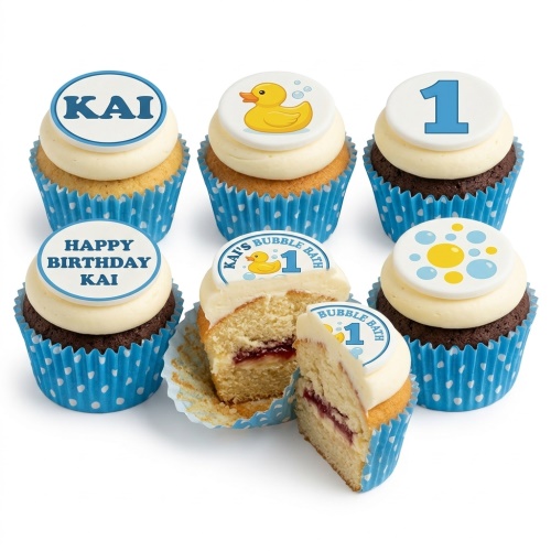 Cupcakes with blue wrappers, white icing, and toppers featuring a rubber duck, bubbles, and the number 1.