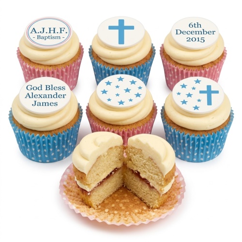 Close-up of vanilla cupcakes with cream frosting, blue and pink wrappers, and custom edible toppers featuring crosses, stars, and messages for a baptism.