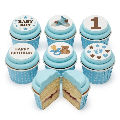 Baby boy themed cupcakes with blue frosting and edible toppers including a number 1, baby shoes, a teddy bear, and "BABY BOY" text.