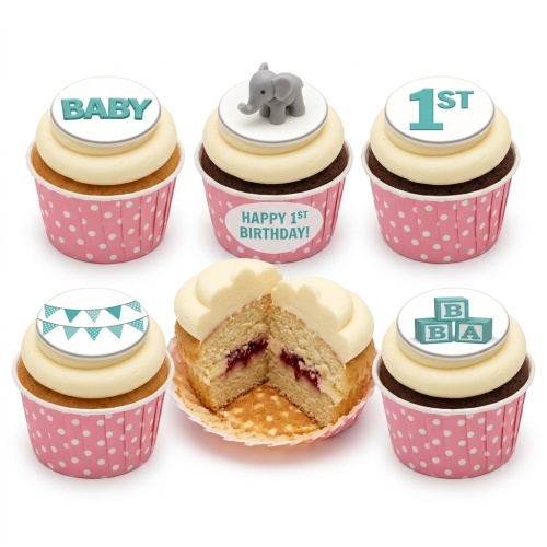 Pink polka dot cupcakes with white icing, featuring 'BABY', '1ST', baby blocks, and a grey elephant topper.