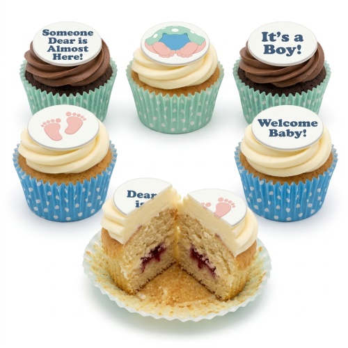 Vanilla and chocolate cupcakes with white frosting, blue and mint green polka dot cases, and baby-themed edible toppers.