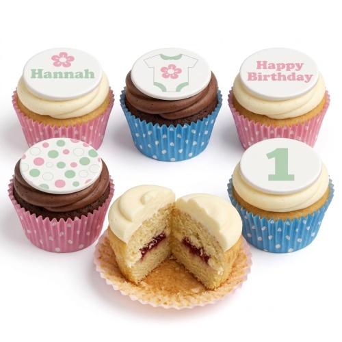 Vanilla and chocolate cupcakes with baby grow, number 1, and polka dot toppers.