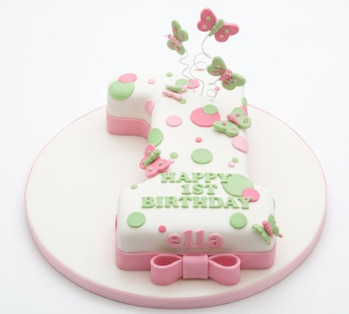 Number 1 shaped cake with pink and green butterflies and polka dots, for a baby girl's 1st birthday.
