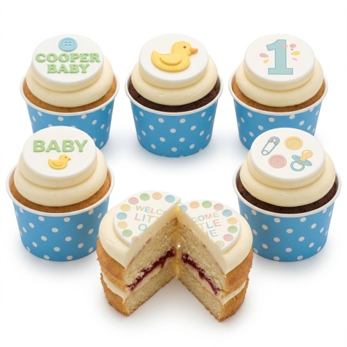 Assortment of baby-themed cupcakes with rubber duck, buttons, and '1' topper in blue wrappers.
