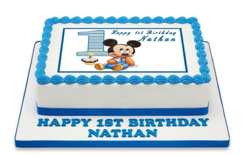 White rectangular cake with blue trim, featuring a baby Mickey Mouse 1st birthday edible image and custom message.
