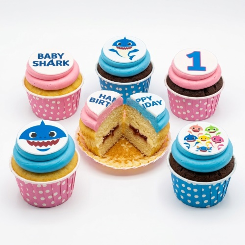 Baby Shark themed cupcakes with blue and pink frosting, featuring character and custom age toppers.