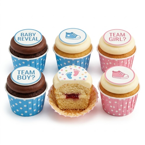 Assortment of gender reveal cupcakes with 'Baby Reveal', 'Team Boy?', 'Team Girl?' toppers, baby shoes, and footprints.