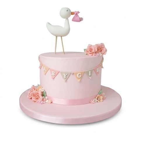 Pink baby shower cake with a white stork topper, 'BABY GIRL' bunting, and pastel sugar flowers.