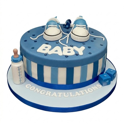 Round blue and white baby shower cake for boys with baby shoes, bottle, blocks, and "BABY" message.