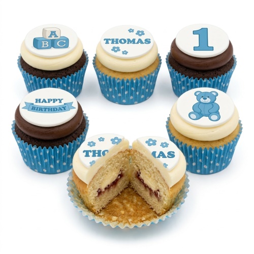 Blue and white 1st birthday cupcakes for boys with teddy bear, ABC blocks, and custom age toppers.