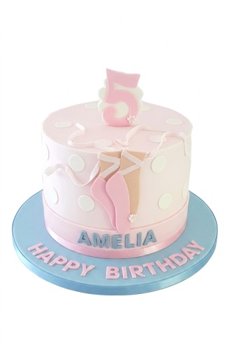 Pink birthday cake with ballet shoes, white polka dots, ribbons, and a custom age topper.