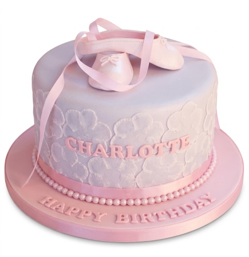 Round pink and lavender birthday cake with ballet shoes, ribbons, and a personalised name.