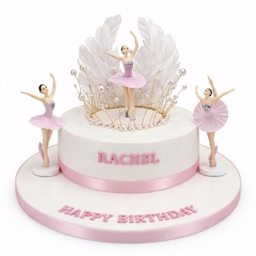 White and pink ballerina birthday cake with three ballet dancer figurines, a feather and pearl crown, and pink ribbon.