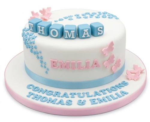 White baby shower cake with blue blocks, pink butterflies, and customisable names.