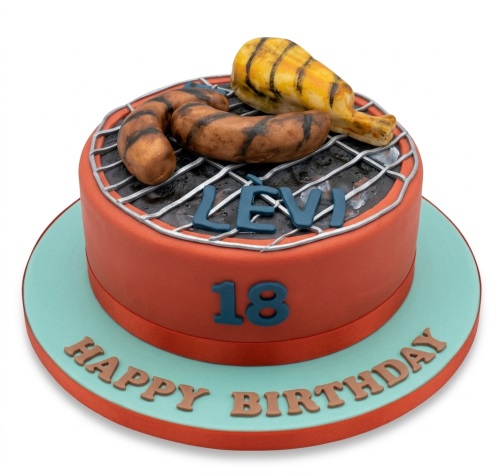 Round orange birthday cake with a grey grill, fondant sausages, and chicken drumstick. Features custom age and personalised name.