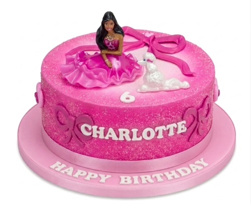 Pink birthday cake with a doll figure, white poodle, bows, and custom name/age.