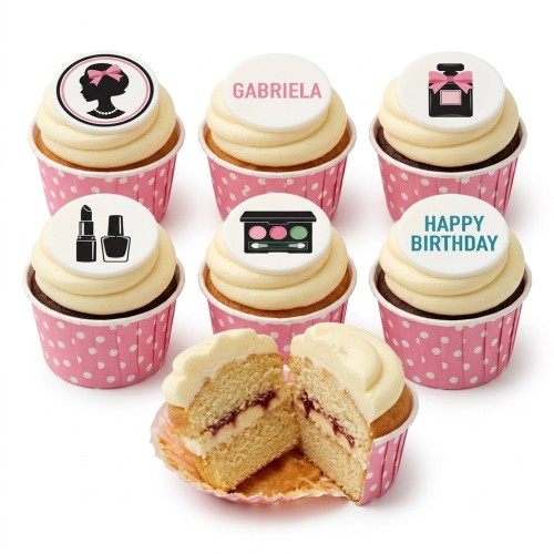 Cupcakes with white frosting and pink polka dot wrappers, topped with makeup and beauty themed edible discs.