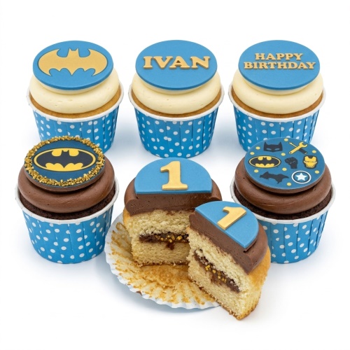 Batman themed cupcakes with blue and yellow logos, superhero icons, and custom age topper.