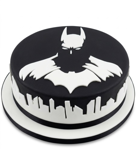 Black and white Batman birthday cake with iconic symbol and city skyline.