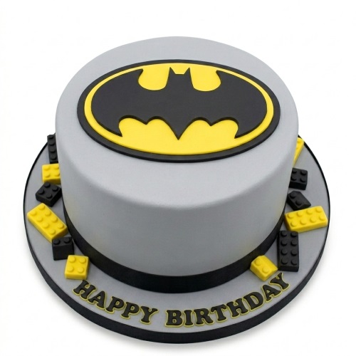 Round grey Batman birthday cake with black and yellow logo and Lego-style blocks.