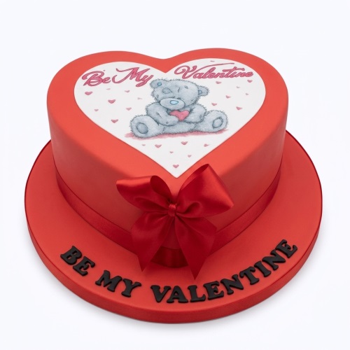 Red heart-shaped cake with a teddy bear holding a heart and "Be My Valentine" message.