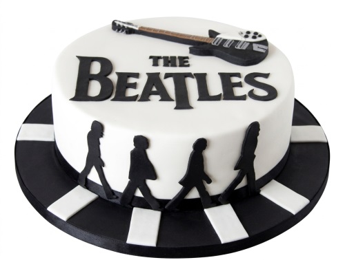 Round white cake with The Beatles logo, black electric guitar, and Abbey Road silhouettes.