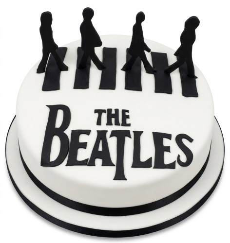 Round white cake with black silhouettes of four figures walking across black stripes, and 'THE BEATLES' text.