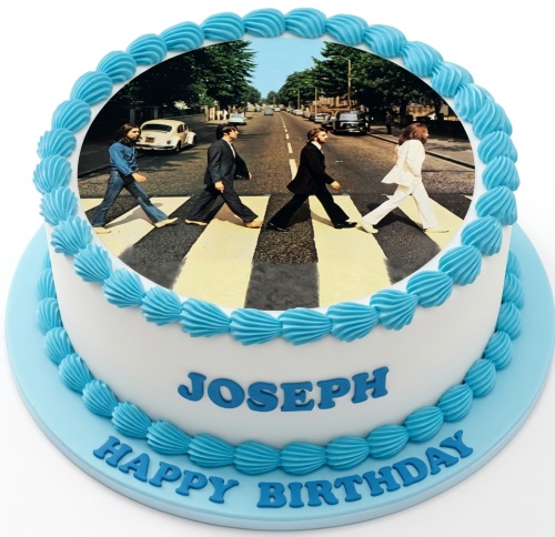 Round white cake with The Beatles Abbey Road image and blue piped icing.