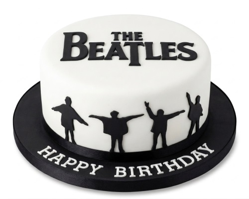 Round white cake with black Beatles logo and band member silhouettes, "Happy Birthday" on the board.