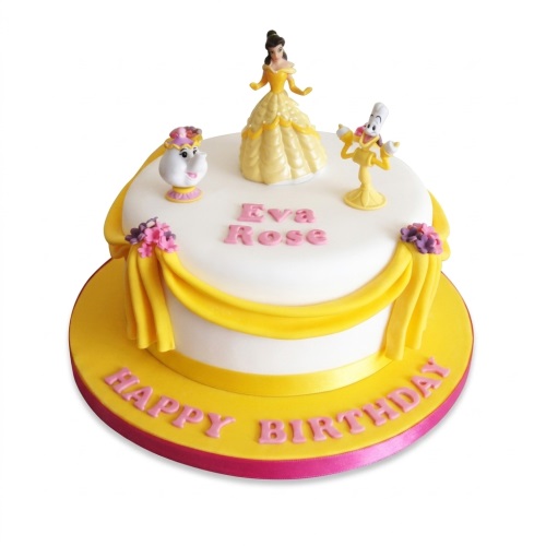 Round white and yellow Beauty and the Beast birthday cake with Belle, Mrs. Potts, and Lumiere figurines.