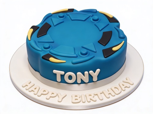 Blue round birthday cake with a spinning top design on top, featuring black and yellow accents, with a personalised name and 'Happy Birthday' message.