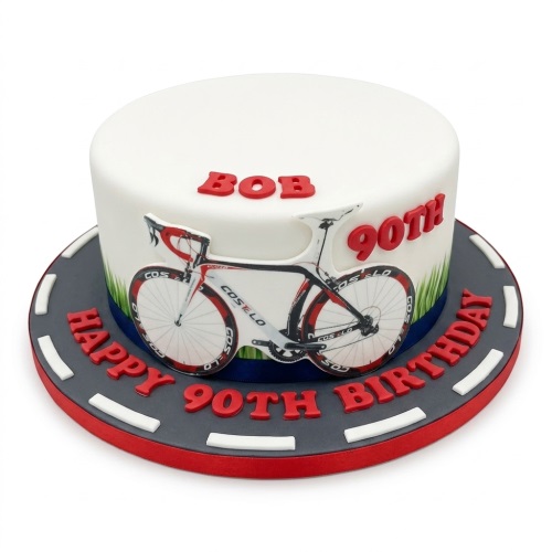 Round white birthday cake with a racing bicycle design and a road-themed base, for a custom age.