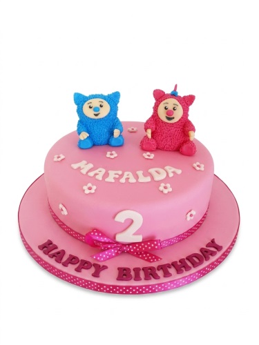 Pink kids character birthday cake with blue and pink fluffy toppers, custom name, and age number.