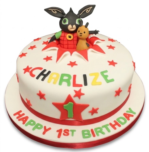 White round 1st birthday cake with Bing Bunny and Flop toppers, red stars, and 'Happy 1st Birthday' message.