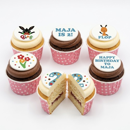Six Bing Bunny themed cupcakes with white and chocolate frosting, pink polka dot cases, and edible character, floral, and number toppers.