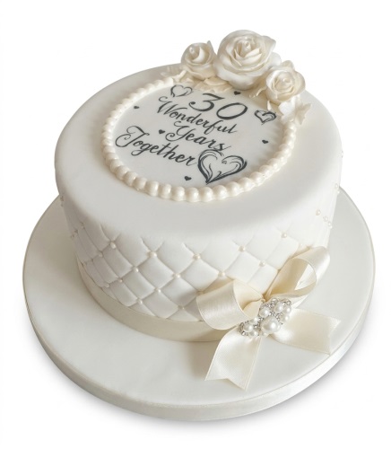 Elegant white anniversary cake with pearl details, white roses, and a custom anniversary message.