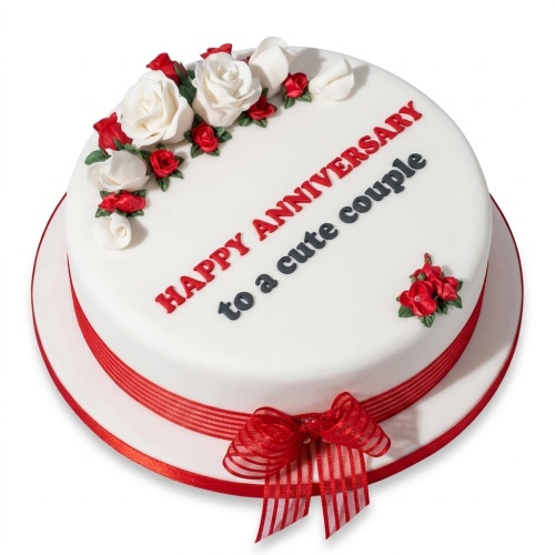 White anniversary cake with red and white sugar roses and a red ribbon.