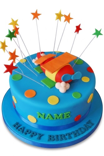 Bright blue round cake with a red, yellow, and orange airplane topper, colourful polka dots, and star decorations on wires. "NAME" and "HAPPY BIRTHDAY" are visible.