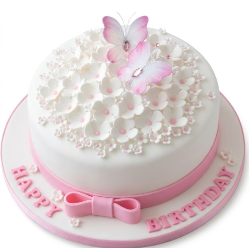 White round birthday cake with pink butterflies and white flowers. Pink ribbon and bow.