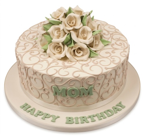 Round cream birthday cake with cream roses, green leaves, and scrollwork, with a custom message.