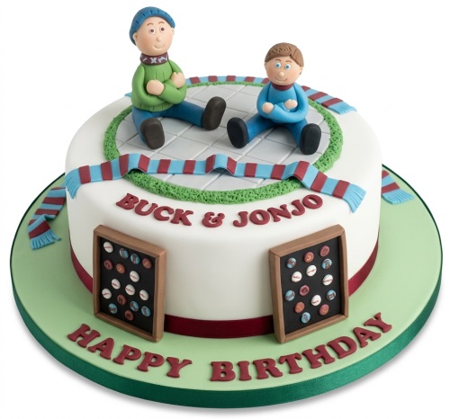 Round white birthday cake with two male fan figures, claret and blue scarves, and personalised message.